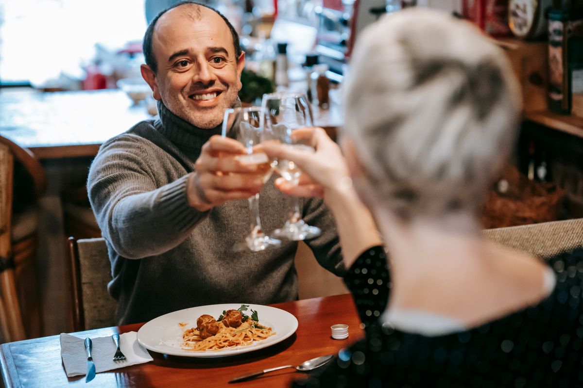 Hands raising a toast with glasses of red wine